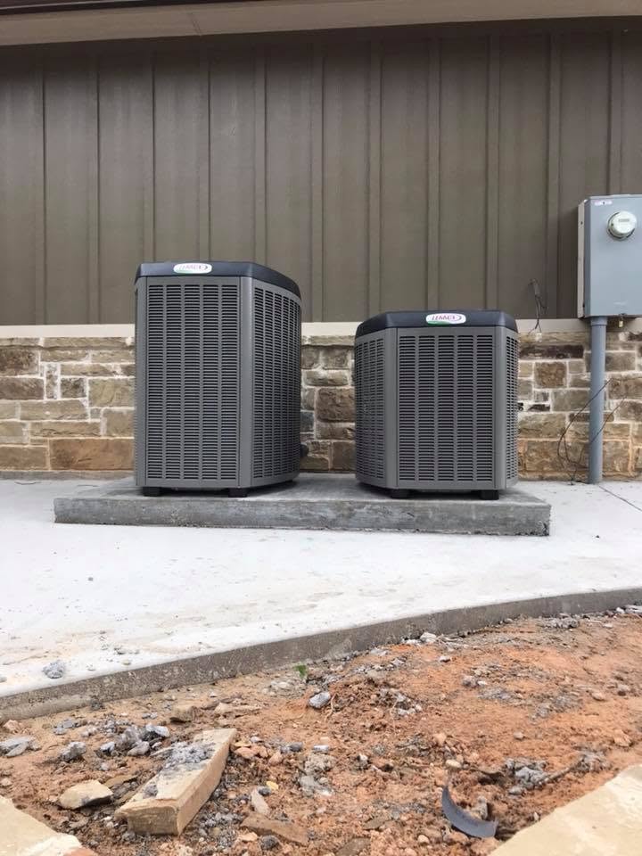 Two Lennox AC condensing units freshly installed on a new concrete pad at a commercial property in Stephenville TX